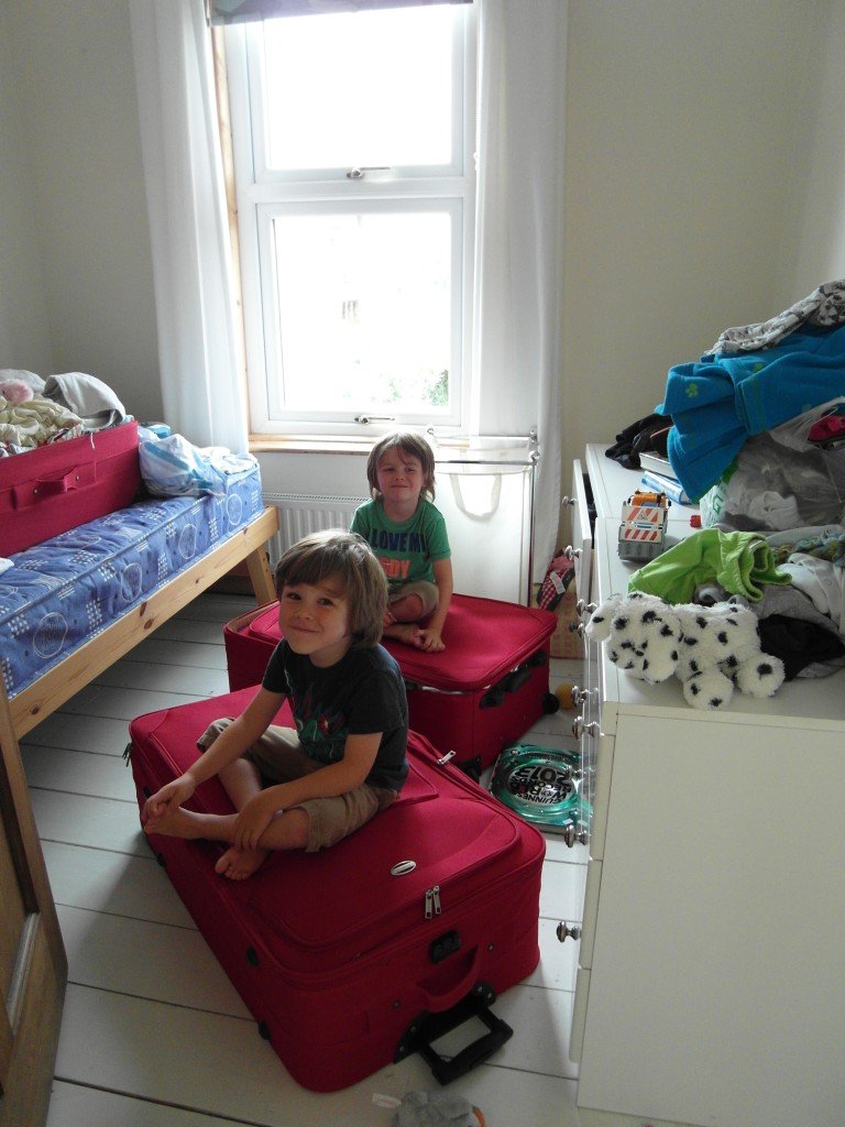 Two boys sitting on suitcases