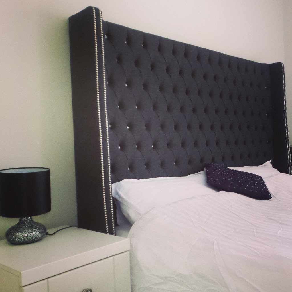 A bedroom with a winged headboard