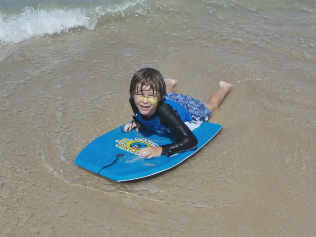 A boy on a body board on holiday