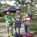 Three kids on scooters after a year in Australia